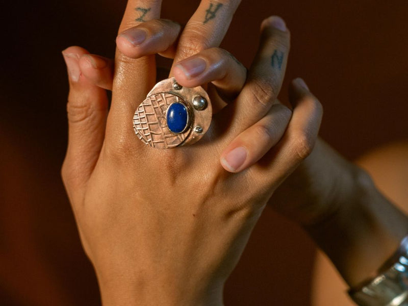 A model showing off a unique copper cocktail ring with Lapis Lazuli stone from Junebug Jewelry Designs